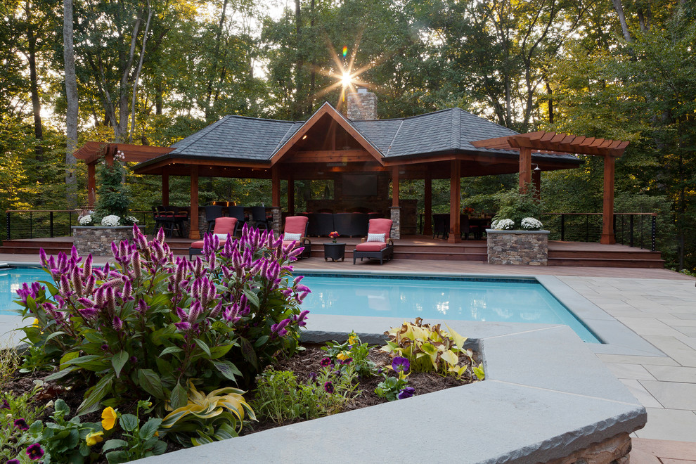 Modelo de casa de la piscina y piscina alargada tropical grande rectangular en patio trasero con entablado