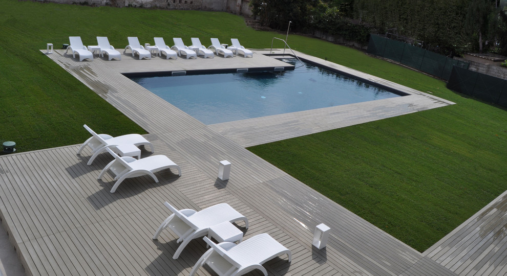 Inspiration pour une grande piscine hors-sol et arrière en L avec une terrasse en bois.