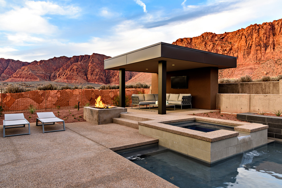 Ispirazione per una piscina american style personalizzata di medie dimensioni e dietro casa con una vasca idromassaggio e lastre di cemento