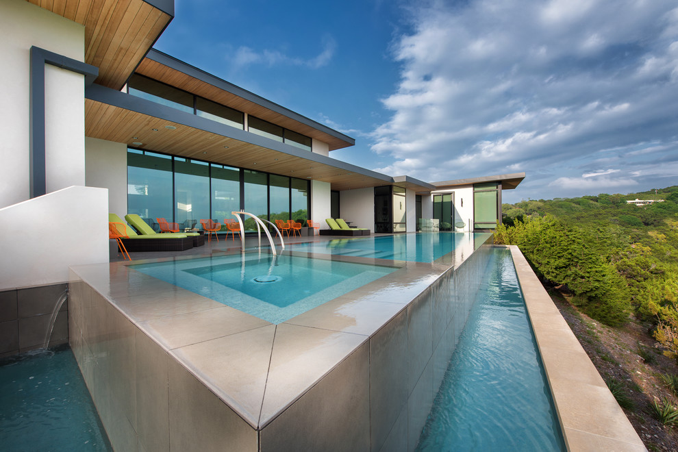 Ispirazione per una grande piscina fuori terra moderna rettangolare dietro casa con fontane