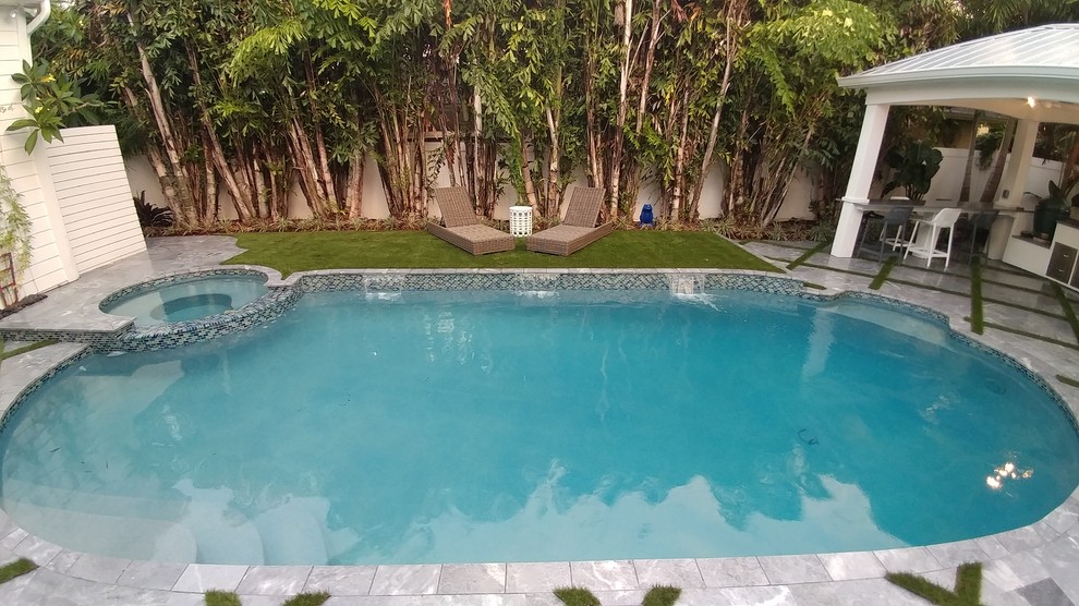Ejemplo de casa de la piscina y piscina natural minimalista pequeña rectangular en patio trasero con adoquines de piedra natural
