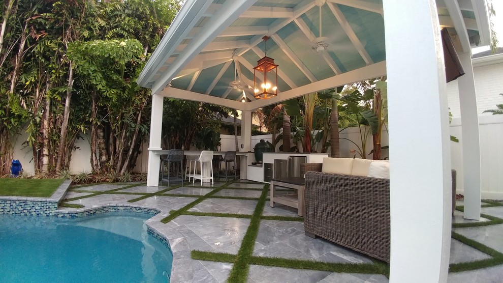 Photo of a small beach style back patio in Tampa with natural stone paving.