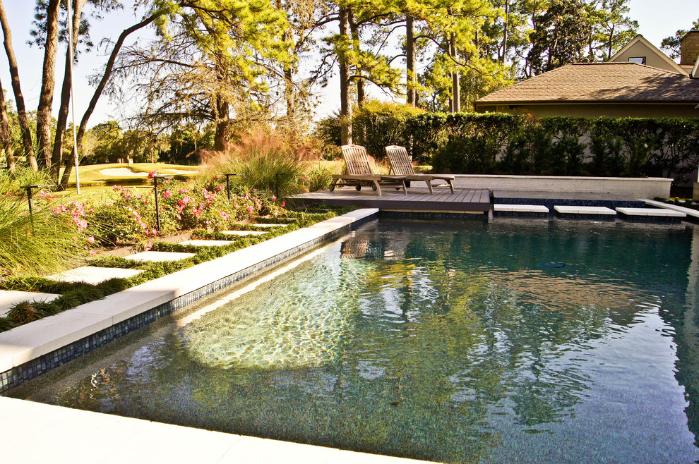 Foto de piscinas y jacuzzis naturales modernos de tamaño medio a medida en patio trasero con adoquines de piedra natural