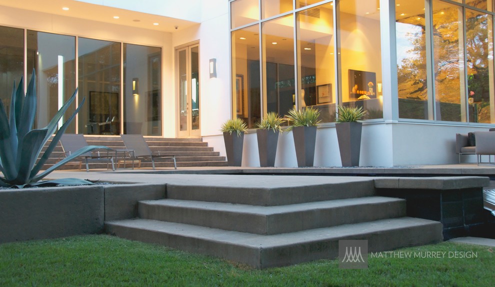 Пример оригинального дизайна: прямоугольный бассейн-инфинити среднего размера на заднем дворе в стиле модернизм с фонтаном и покрытием из бетонных плит