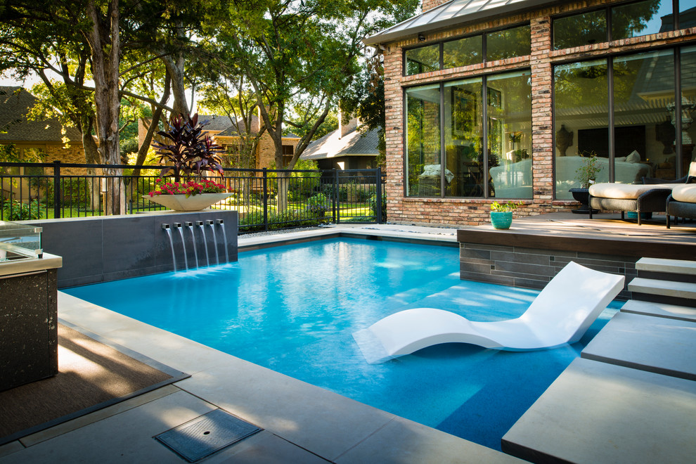 Kleiner Moderner Pool hinter dem Haus in L-Form mit Natursteinplatten in Dallas
