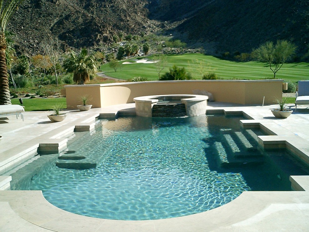 Modelo de piscina moderna extra grande a medida en patio trasero con losas de hormigón