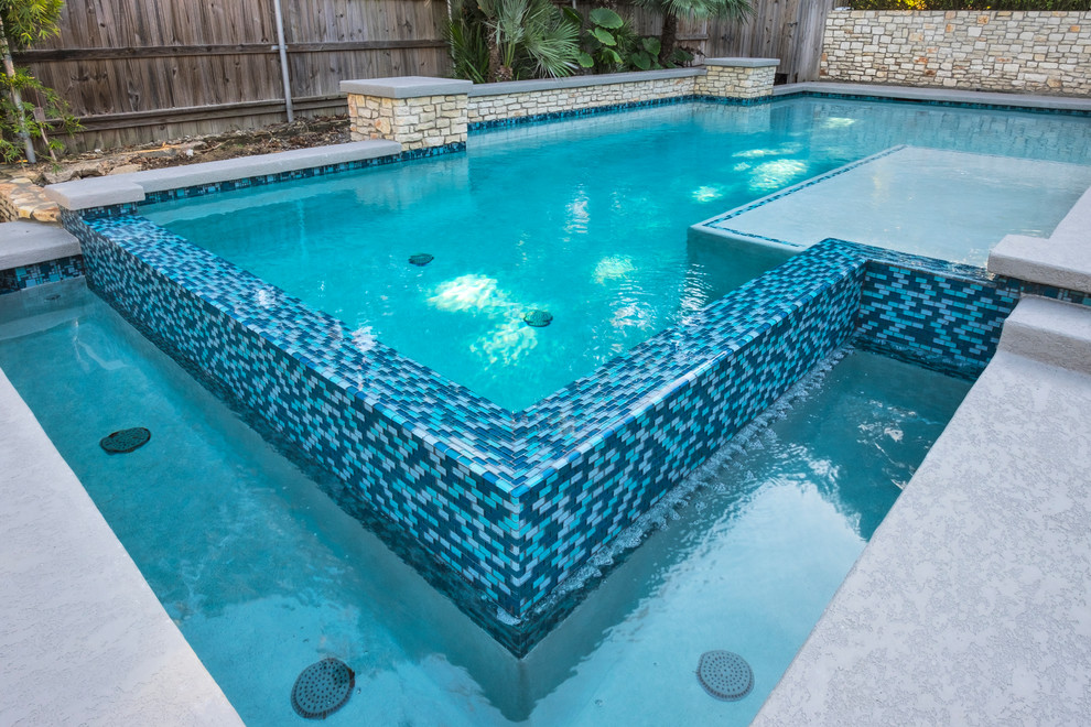 Cette image montre une piscine à débordement et arrière minimaliste de taille moyenne et rectangle avec une terrasse en bois.