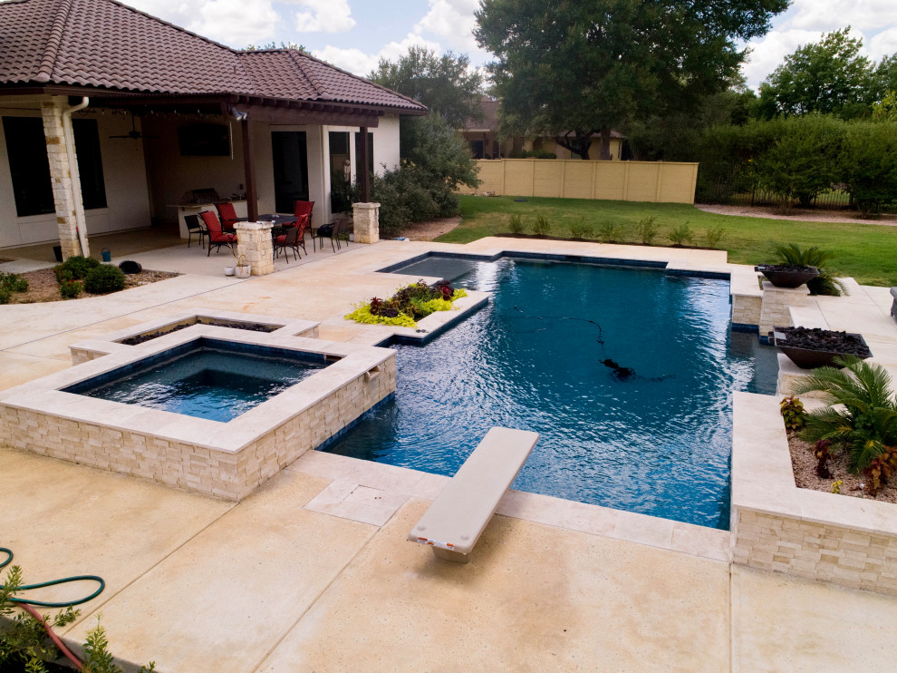 Foto de piscina con fuente contemporánea grande rectangular en patio trasero con losas de hormigón