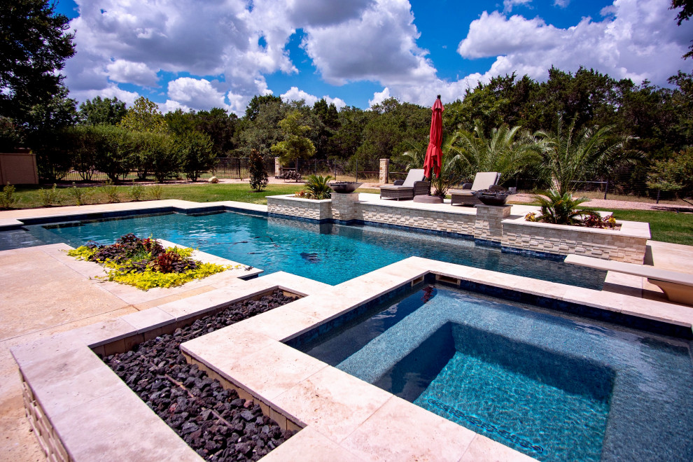 Immagine di una grande piscina design rettangolare dietro casa con fontane e lastre di cemento