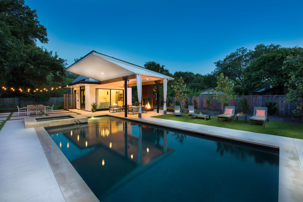 This is an example of a large traditional back rectangular lengths swimming pool in Austin with concrete paving.