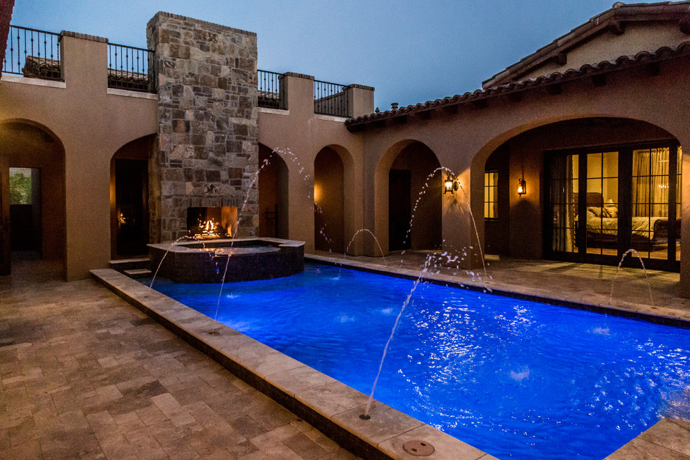 Idee per un'ampia piscina monocorsia country rettangolare dietro casa con fontane e pavimentazioni in pietra naturale
