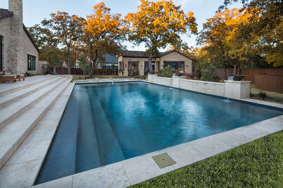 Imagen de piscinas y jacuzzis alargados de estilo de casa de campo de tamaño medio rectangulares en patio trasero con adoquines de hormigón