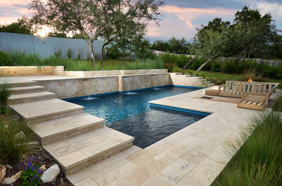 Diseño de piscina natural contemporánea de tamaño medio en forma de L en patio trasero con adoquines de piedra natural