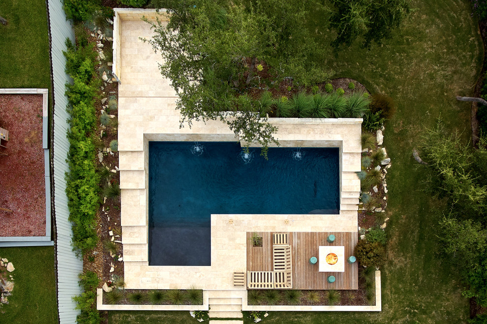 Imagen de piscina natural contemporánea de tamaño medio en forma de L en patio trasero con adoquines de piedra natural