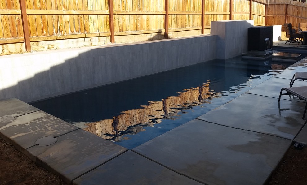 Imagen de piscina moderna pequeña rectangular en patio trasero con losas de hormigón