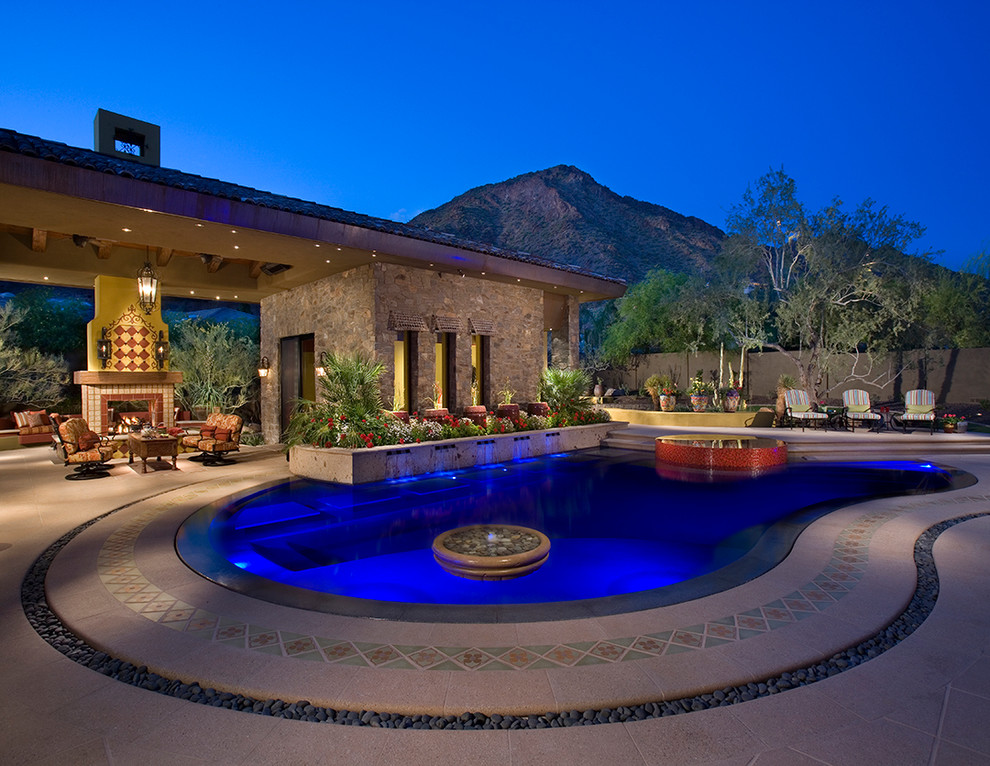 На фото: огромный бассейн-инфинити произвольной формы на заднем дворе в стиле модернизм с джакузи и мощением тротуарной плиткой