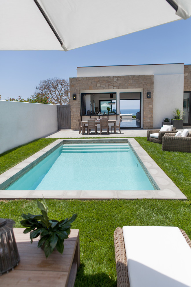 Foto de piscina actual de tamaño medio rectangular en patio con losas de hormigón