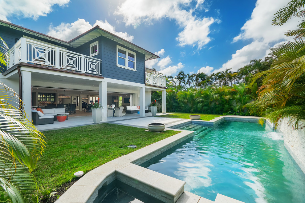 Foto di una piscina tropicale rettangolare di medie dimensioni e dietro casa con fontane