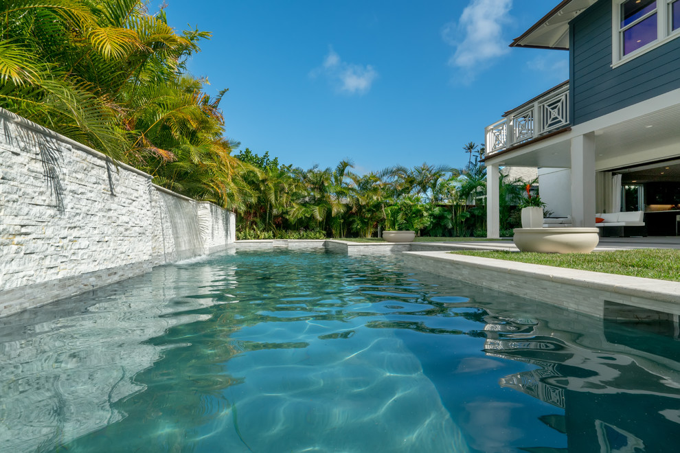 Ejemplo de piscina con fuente exótica de tamaño medio rectangular en patio trasero