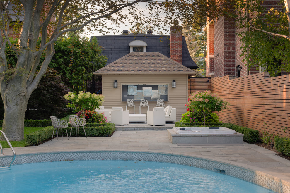 Idee per una grande piscina monocorsia minimal rotonda dietro casa con pavimentazioni in pietra naturale e una vasca idromassaggio