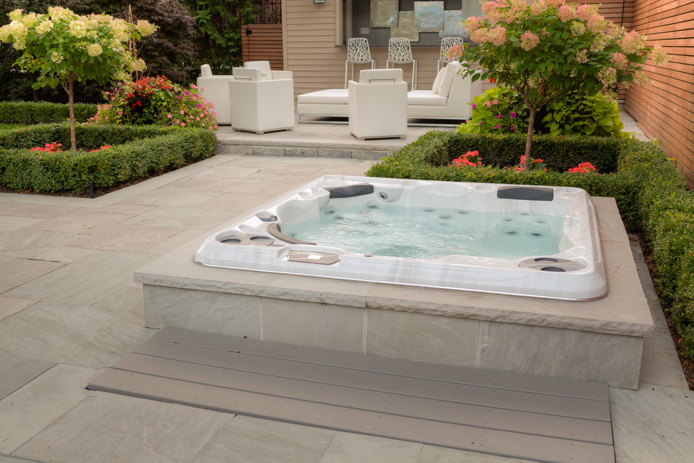 Large trendy backyard stone and round lap hot tub photo in Toronto