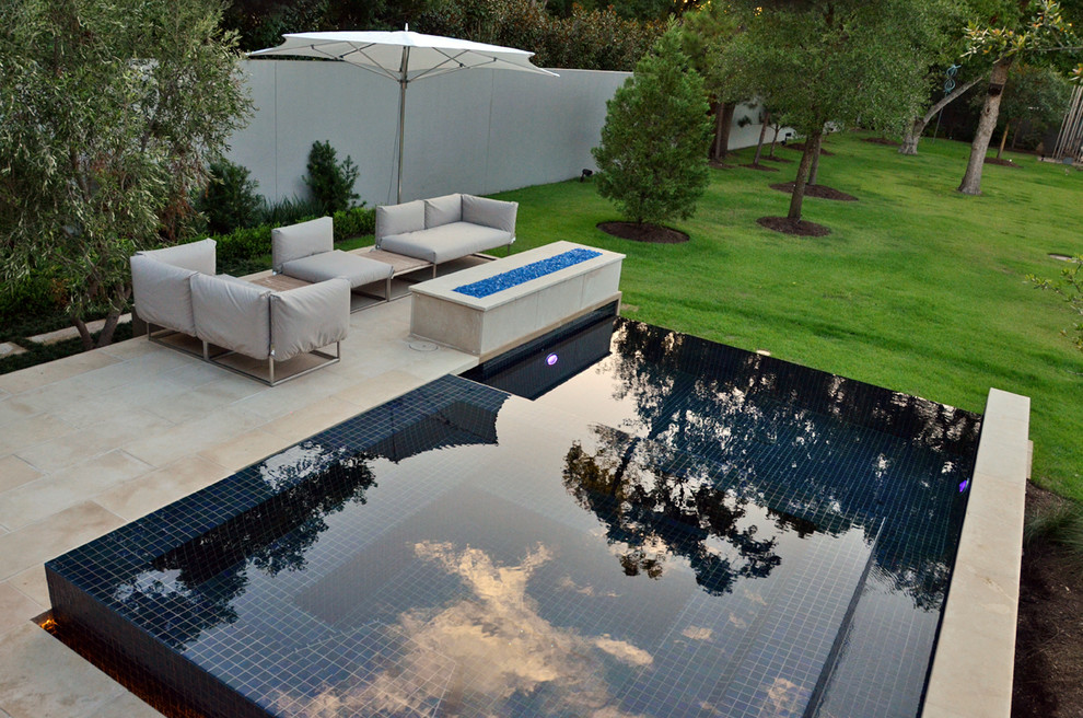 Cette photo montre une petite piscine à débordement et arrière moderne sur mesure avec un point d'eau et du carrelage.