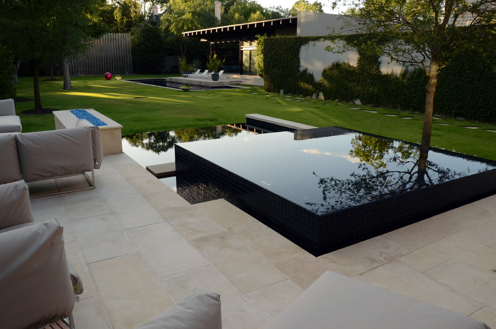 Imagen de piscina con fuente infinita moderna pequeña rectangular en patio trasero con suelo de baldosas