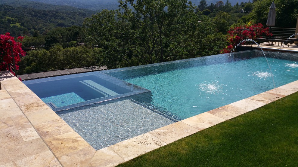 На фото: большой прямоугольный бассейн-инфинити на заднем дворе в стиле модернизм с домиком у бассейна и покрытием из плитки