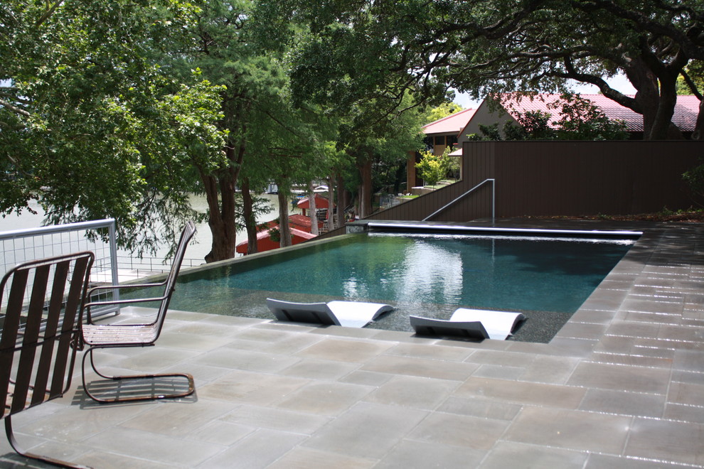 Example of a mid-sized minimalist backyard tile and rectangular infinity hot tub design in Austin