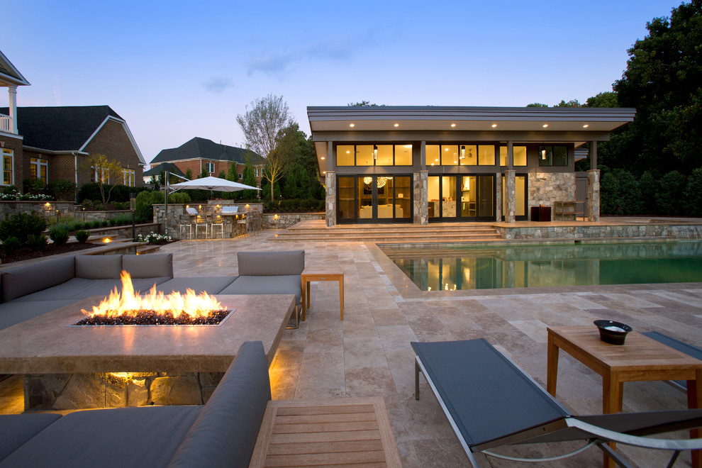 Imagen de piscina clásica grande en patio trasero con adoquines de piedra natural