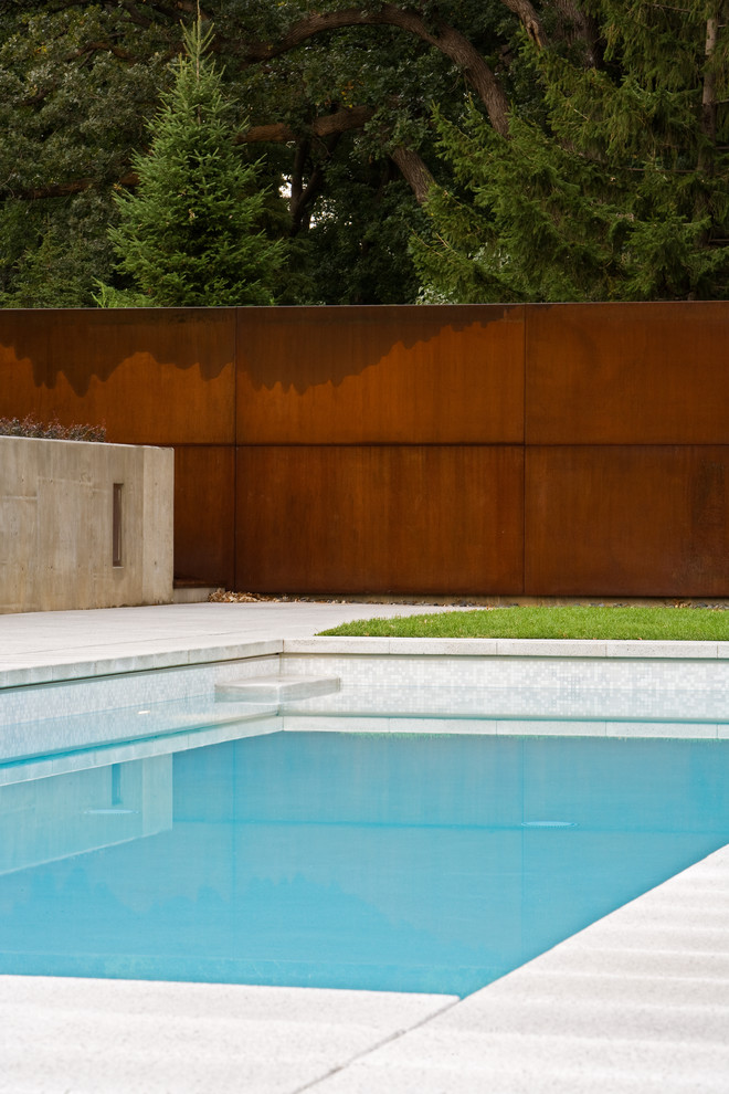 Idee per una piscina minimalista rettangolare di medie dimensioni e dietro casa con pavimentazioni in cemento