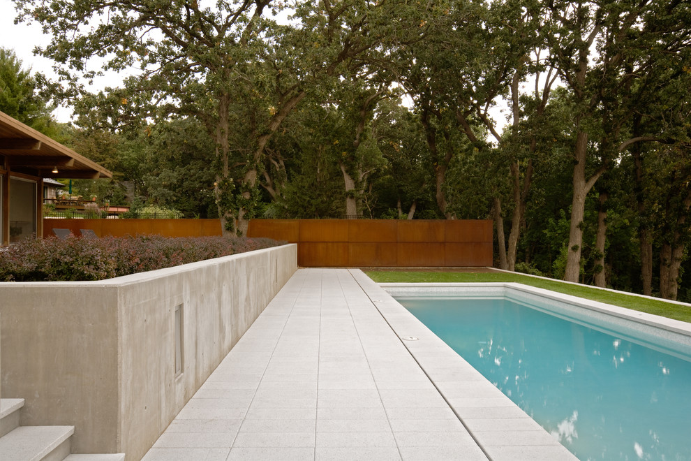 Immagine di una piscina moderna rettangolare di medie dimensioni e dietro casa con pavimentazioni in cemento