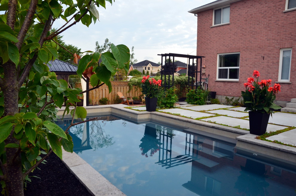 Design ideas for a small modern back rectangular swimming pool in Toronto with concrete slabs.