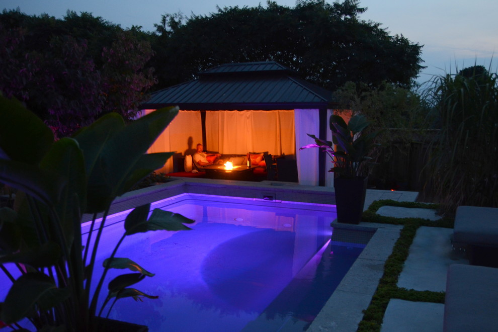 На фото: маленький прямоугольный бассейн на заднем дворе в современном стиле с покрытием из бетонных плит для на участке и в саду с