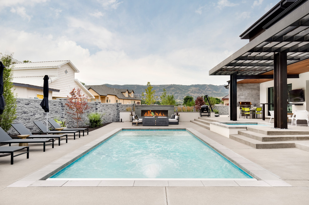 Foto de piscinas y jacuzzis contemporáneos rectangulares en patio trasero con losas de hormigón