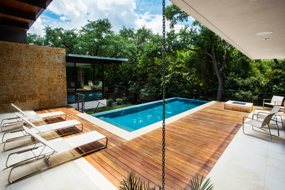 Ispirazione per una piscina a sfioro infinito minimalista rettangolare di medie dimensioni e dietro casa con pedane