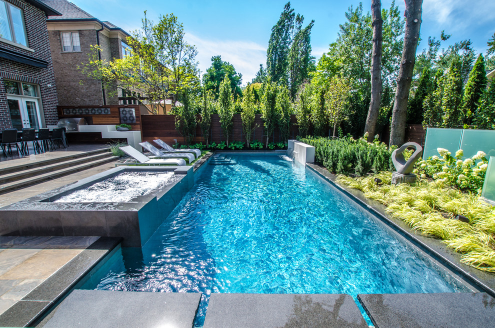 Kleiner Moderner Pool hinter dem Haus in rechteckiger Form mit Wasserspiel und Natursteinplatten in Toronto