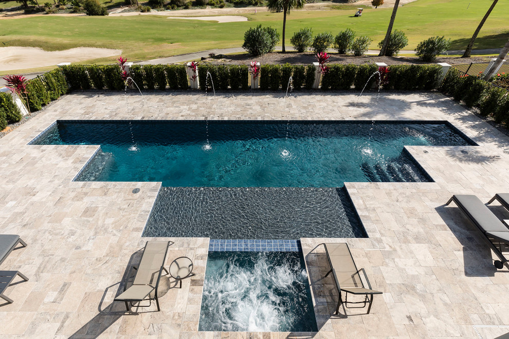 Großer Moderner Pool hinter dem Haus in individueller Form mit Natursteinplatten in Orlando