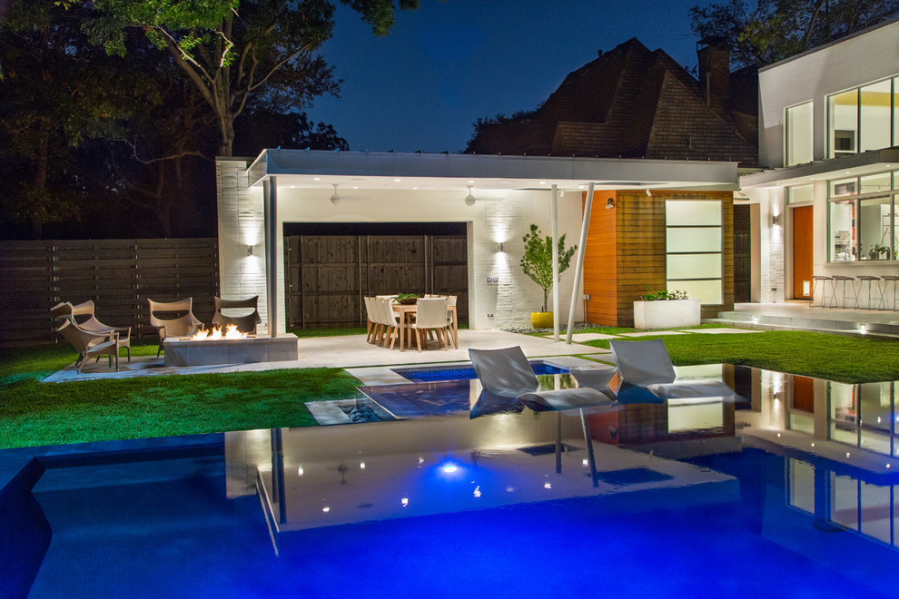 Ispirazione per una piscina a sfioro infinito design rettangolare di medie dimensioni e dietro casa con una vasca idromassaggio e pavimentazioni in cemento
