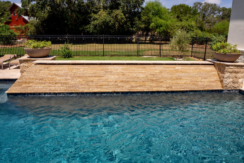 Imagen de piscina con fuente tradicional renovada de tamaño medio rectangular en patio trasero con adoquines de piedra natural
