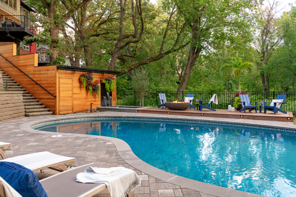 Example of a mid-sized trendy backyard stone pool design in Minneapolis