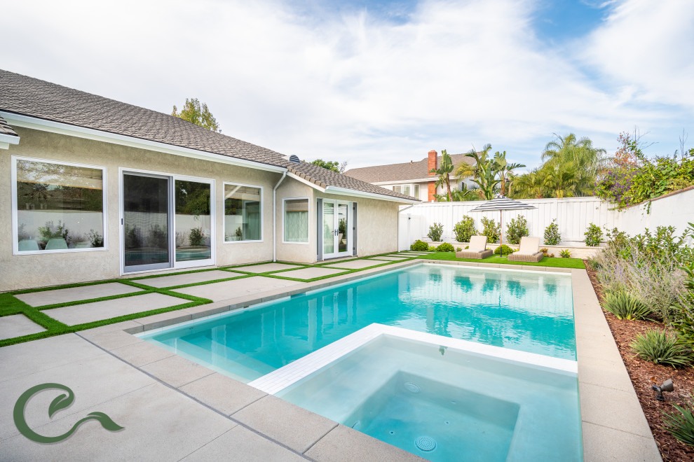 Imagen de piscinas y jacuzzis alargados actuales de tamaño medio rectangulares en patio trasero con losas de hormigón