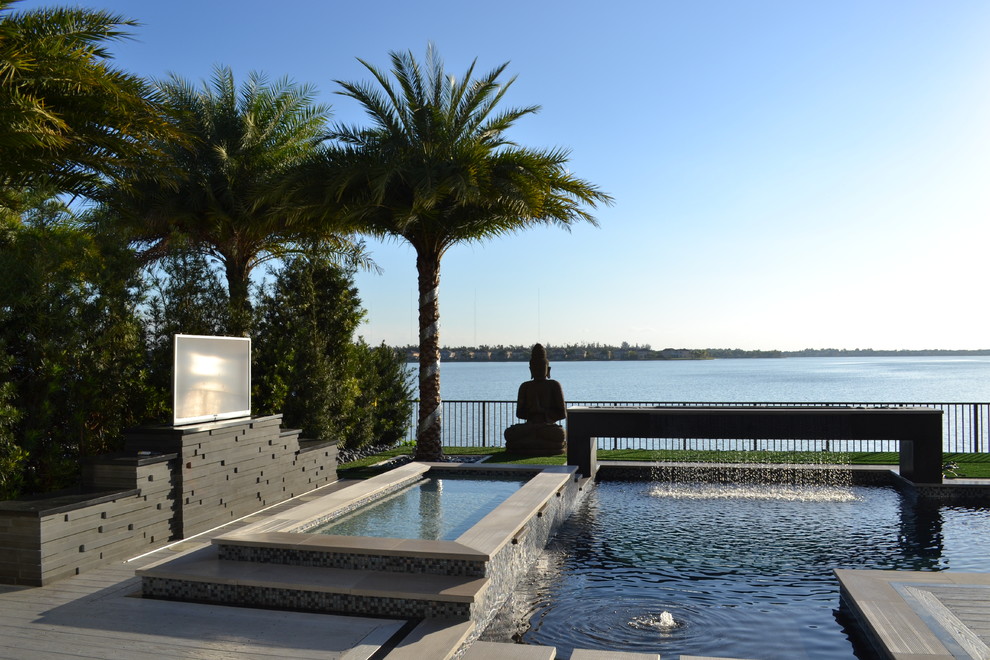 Inspiration for an expansive contemporary back custom shaped hot tub in Miami with decking.