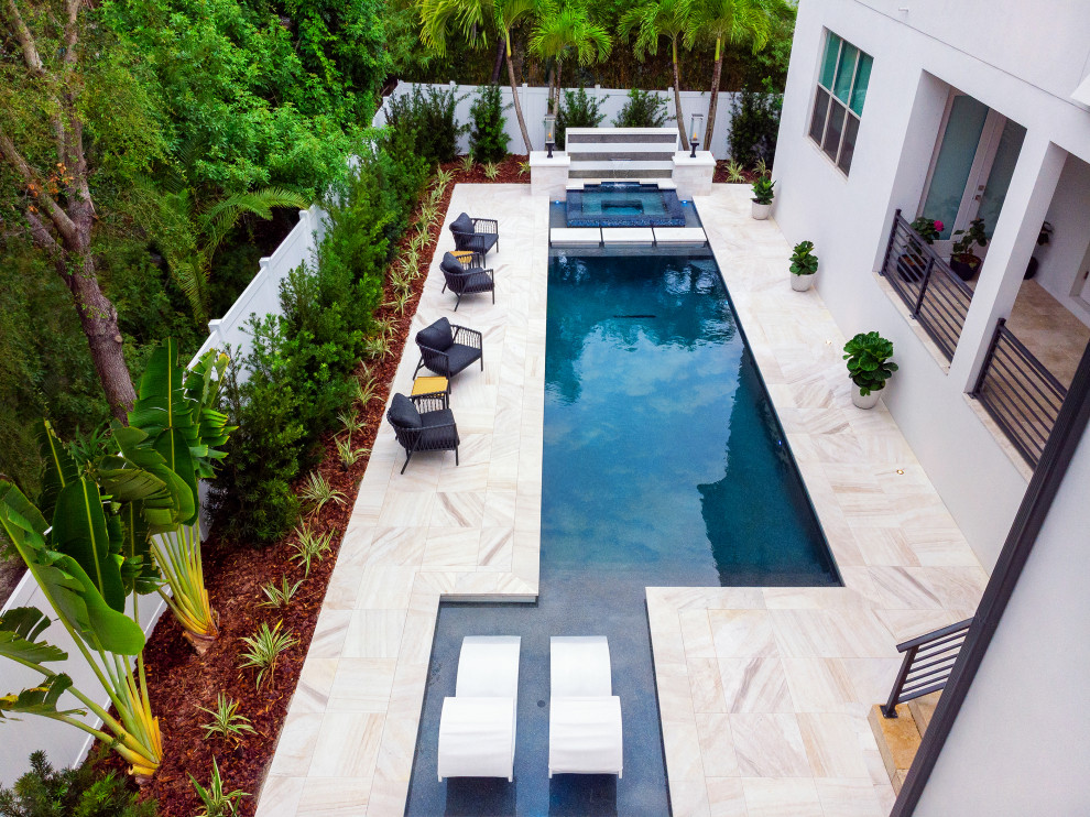 На фото: бассейн среднего размера, произвольной формы на заднем дворе в современном стиле с покрытием из плитки с