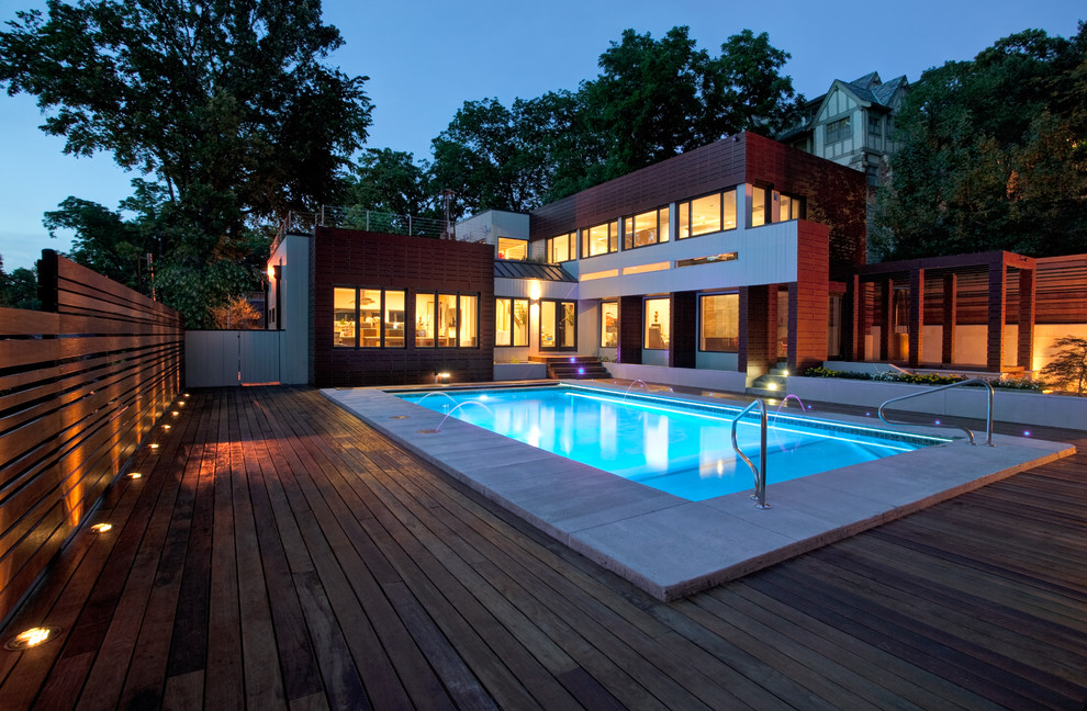 Réalisation d'une piscine minimaliste rectangle avec une terrasse en bois.