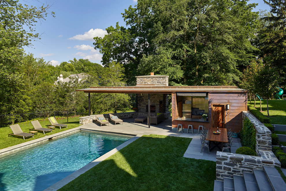 Foto di una piscina design rettangolare dietro casa con una dépendance a bordo piscina e pavimentazioni in pietra naturale