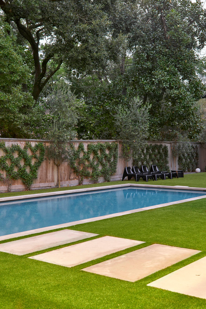На фото: большой прямоугольный бассейн на заднем дворе в современном стиле с покрытием из каменной брусчатки с