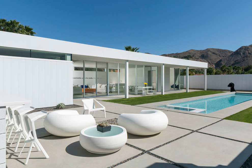 Свежая идея для дизайна: прямоугольный бассейн на заднем дворе в стиле модернизм с мощением тротуарной плиткой - отличное фото интерьера