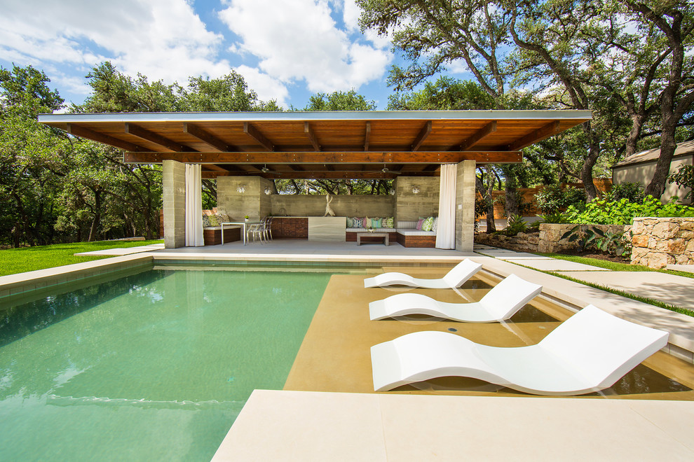 Пример оригинального дизайна: большой спортивный, прямоугольный бассейн на заднем дворе в стиле модернизм с домиком у бассейна и покрытием из каменной брусчатки