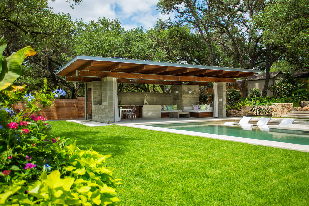 Großer Moderner Pool hinter dem Haus in rechteckiger Form mit Natursteinplatten in Austin